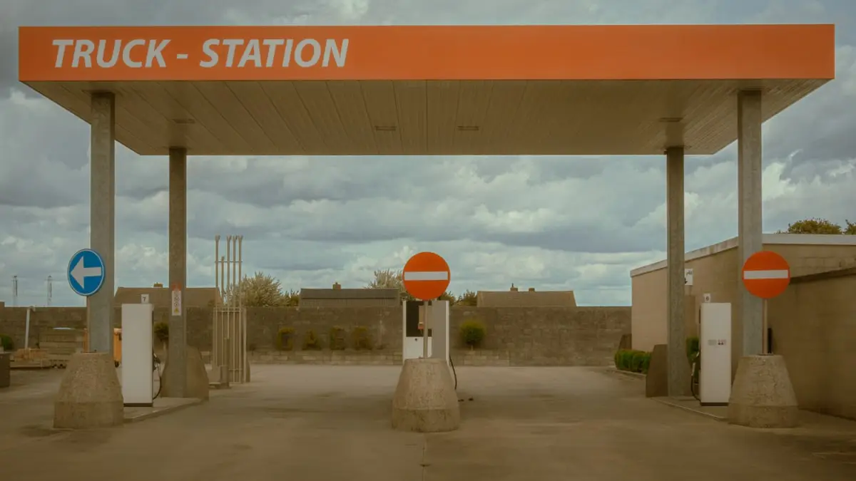 Trucks parked at a truck stop under an overcast sky